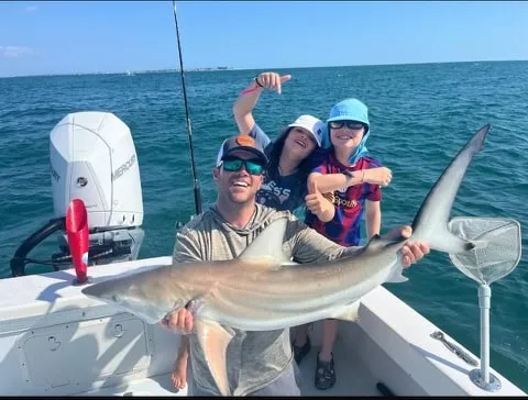 Anglers celebrating a blacktip shark catch on a nearshore charter